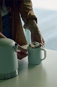 写真：ドリップバッグでコーヒーを淹れる女性